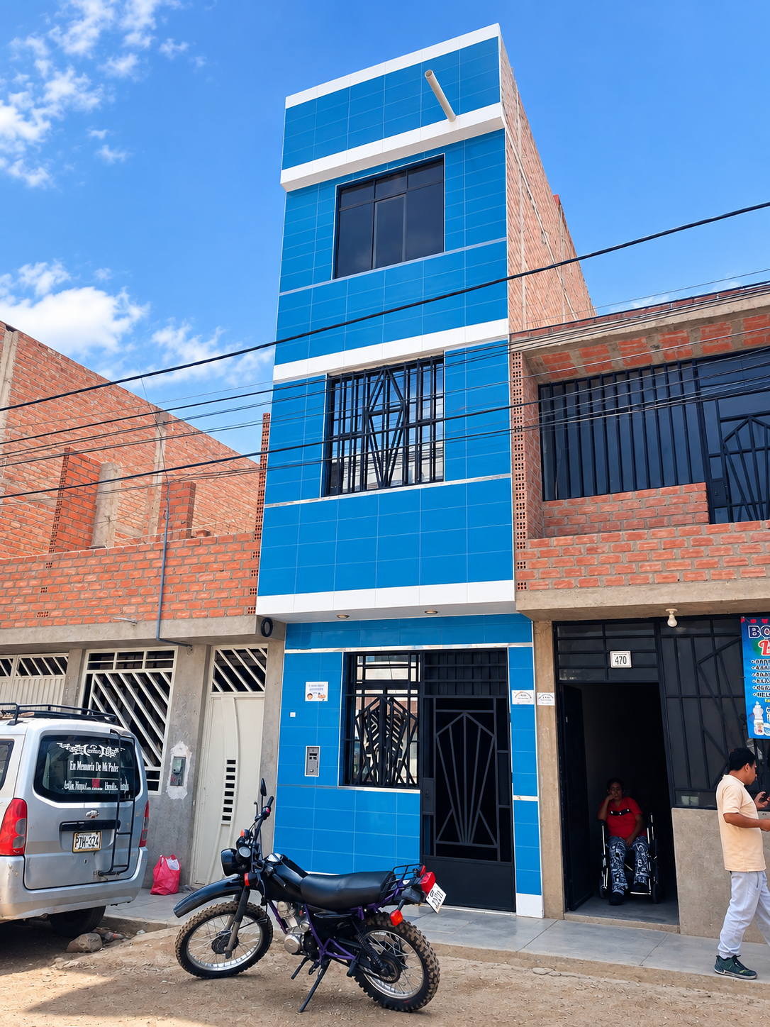 Fachada azul entre ladrillos y cables